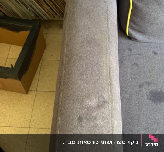 כתמים על ספת בד אפורה לפני ניקוי